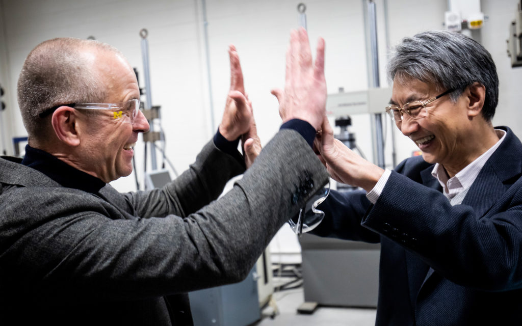 Volker Sick and Victor Li giving each other a high five handshake.